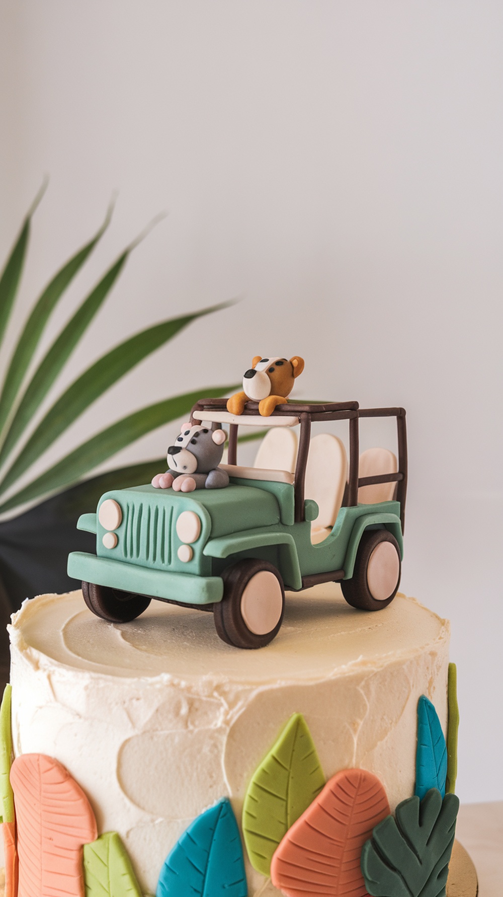 A Safari Vehicle Cake Topper featuring a green jeep with animal figures on top, placed on a cake decorated with colorful leaves.